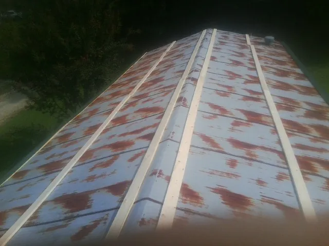 Rusted metal roof panels with new wood purlins before replacement — Storm Damage Roof Repair in Devon by Roofing Brothers